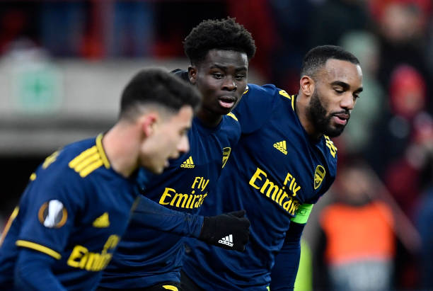 Arsenal's English striker Bukayo Saka (C) celebrates with teammate Arsenal's French striker Alexandre Lacazette (R) after scoring a goal during the...