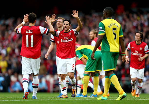 LONDON, ENGLAND - OCTOBER 19: Mesut Oezil of Arsenal (11) celebrates with Mikel Arteta as he scores their fourth goal during the Barclays Premier L...