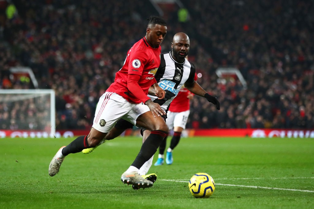 MANCHESTER, ENGLAND - DECEMBER 26: Aaron Wan-Bissaka of Manchester United crosses the ball under pressure from Jetro Willems of Newcastle United du...