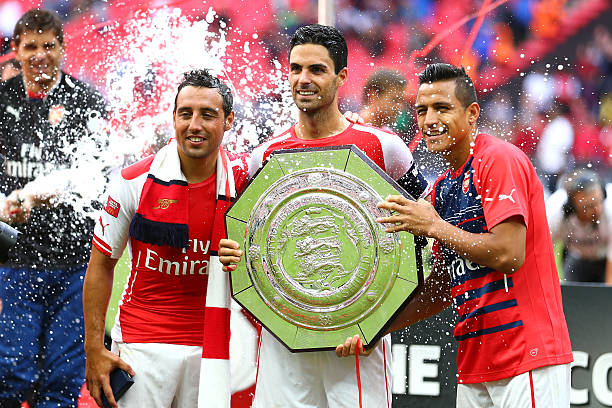 LONDON, ENGLAND - AUGUST 10: (L-R) Santi Cazorla, Mikel Arteta and Alexis Sanchez of Arsenal pose with the trophy after the FA Community Shield match between Manchester City and Arsenal at Wembley Stadium on August 10, 2014 in London, England. (Photo by Clive Mason/Getty Images)