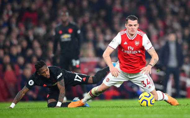 LONDON, ENGLAND - JANUARY 01: Granit Xhaka of Arsenal is challenged by Fred of Manchester United during the Premier League match between Arsenal FC and Manchester United at Emirates Stadium on January 01, 2020 in London, United Kingdom. (Photo by Clive Mason/Getty Images)