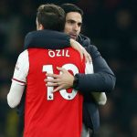 Arsenal's Spanish head coach Mikel Arteta (R) embraces Arsenal's German midfielder Mesut Ozil (L) on the pitch after the English Premier League football match between Arsenal and Manchester United at the Emirates Stadium in London on January 1, 2020. - Arsenal won the game 2-0. (Photo by Ian KINGTON / IKIMAGES / AFP)