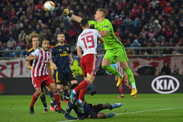 Arsenal's German goalkeeper Bernd Leno (R) punches the ball clear during the UEFA Europa League round of 32 first leg football match between Olympiakos and Arsenal at the Karaiskakis Stadium in Piraeus, near Athens, on February 20, 2020.