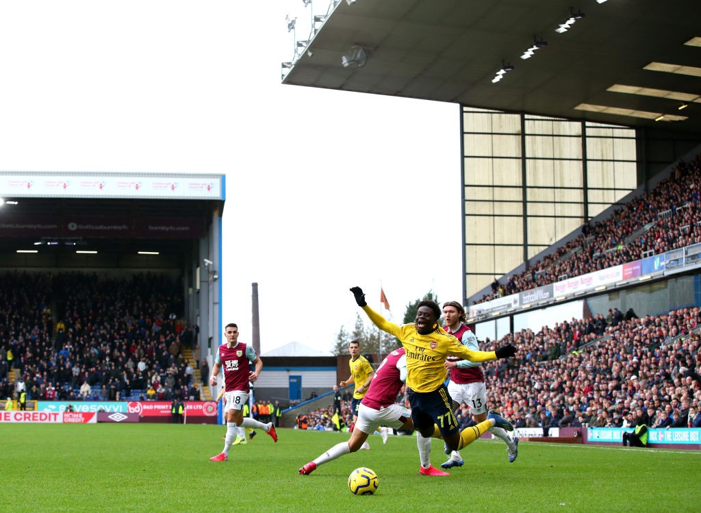 BURNLEY, ENGLAND - FEBRUARY 02: Bukayo Saka of Arsenal is fouled by Matthew Lowton of Burnley during the Premier League match between Burnley FC an...