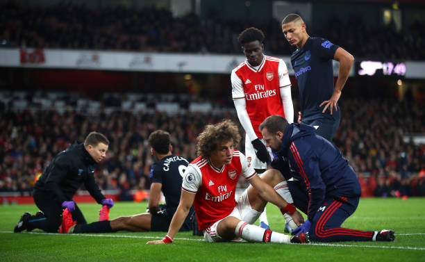 David Luiz of Arsenal and Dominic Calvert-Lewin of Everton receive medical treatment during the Premier League match between Arsenal FC and Everton FC at Emirates Stadium on February 23, 2020 in London, United Kingdom.