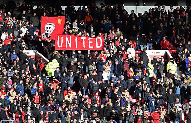 Manchester United fans hold a banner depicting Manchester United's Portuguese manager Jose Mourinho ahead of the English Premier League football ma...