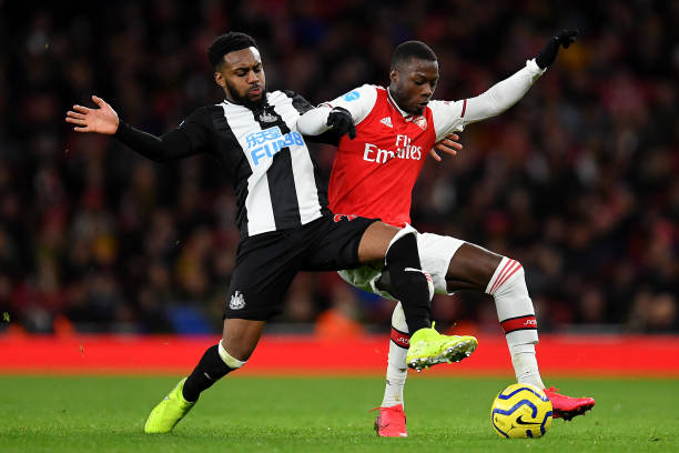 Danny Rose of Newcastle United tackles Nicolas Pepe of Arsenal during the Premier League match between Arsenal FC and Newcastle United at Emirates Stadium on February 16, 2020 in London, United Kingdom.