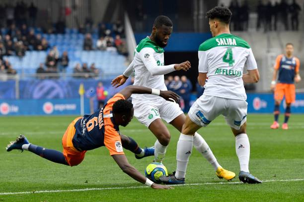 Montpellier's French defender Junior Sambia (L) fights for the ball with Saint-Etienne's French midfielder Jean-Eudes Aholou (C) and Saint-Etienne'...