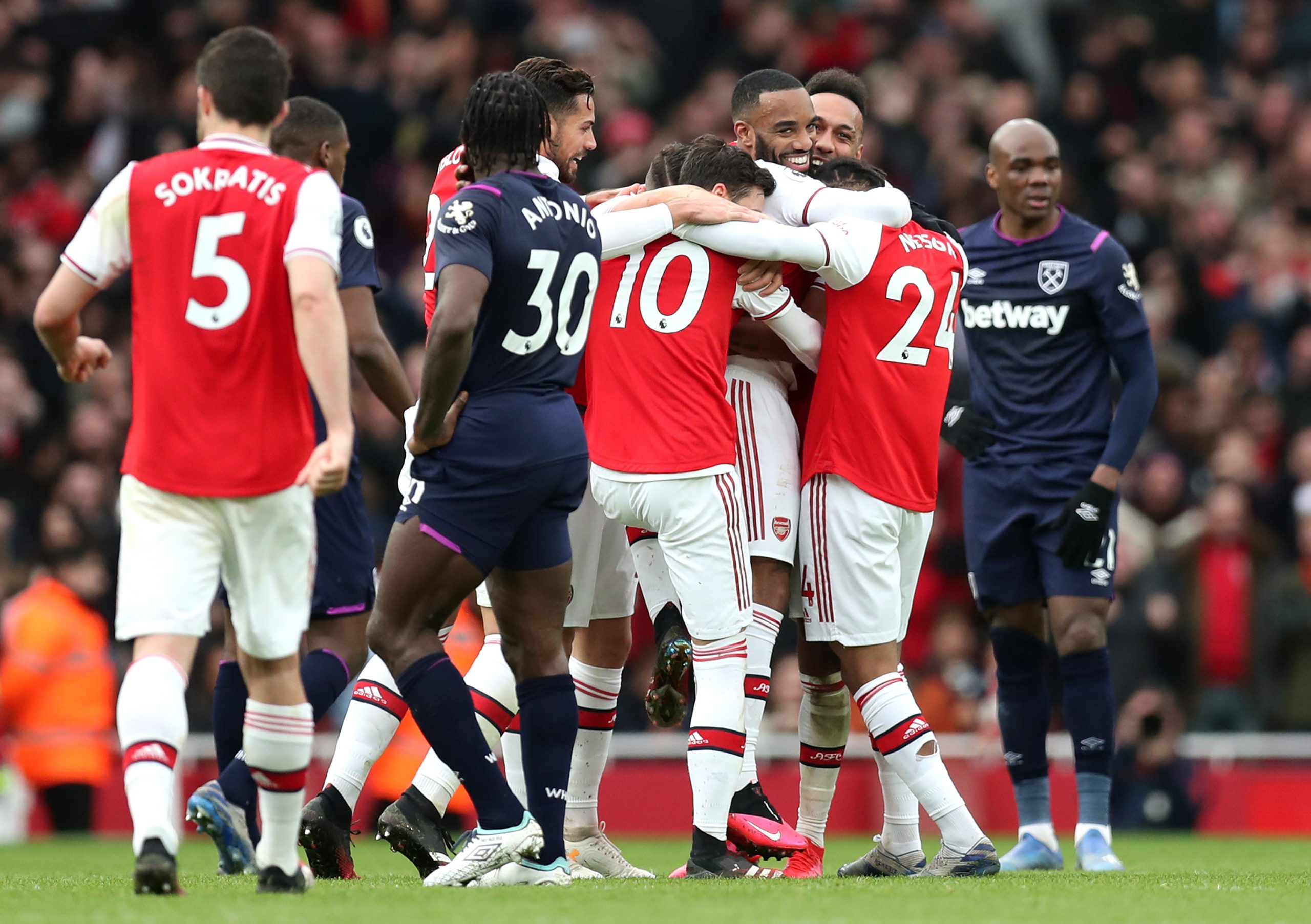 Alexandre Lacazette of Arsenal celebrates with teammates after scoring his team's first goal which was given by VAR during the Premier League match...