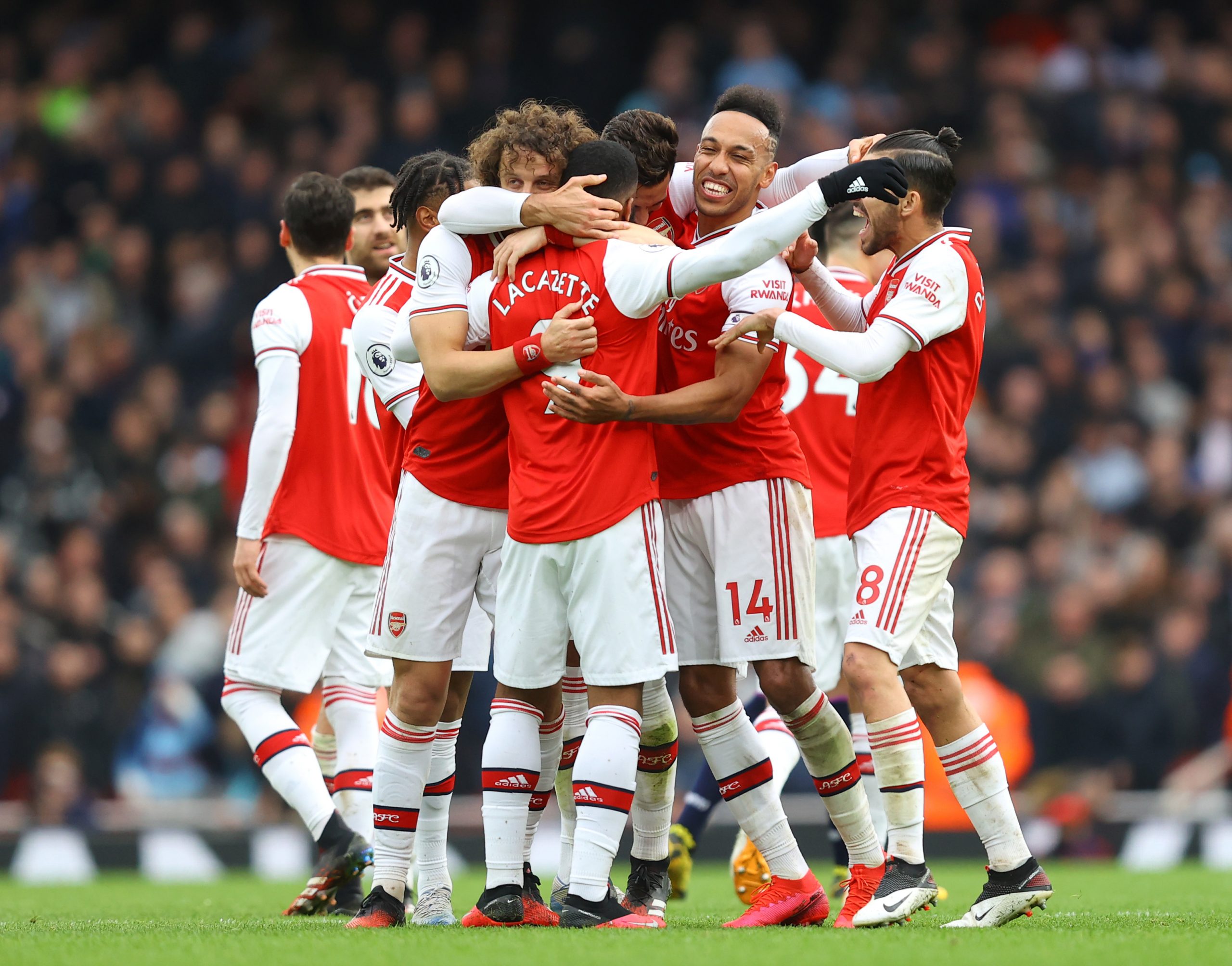 Alexandre Lacazette of Arsenal celebrates with teammates after scoring his team's first goal which was given by VAR during the Premier League match...