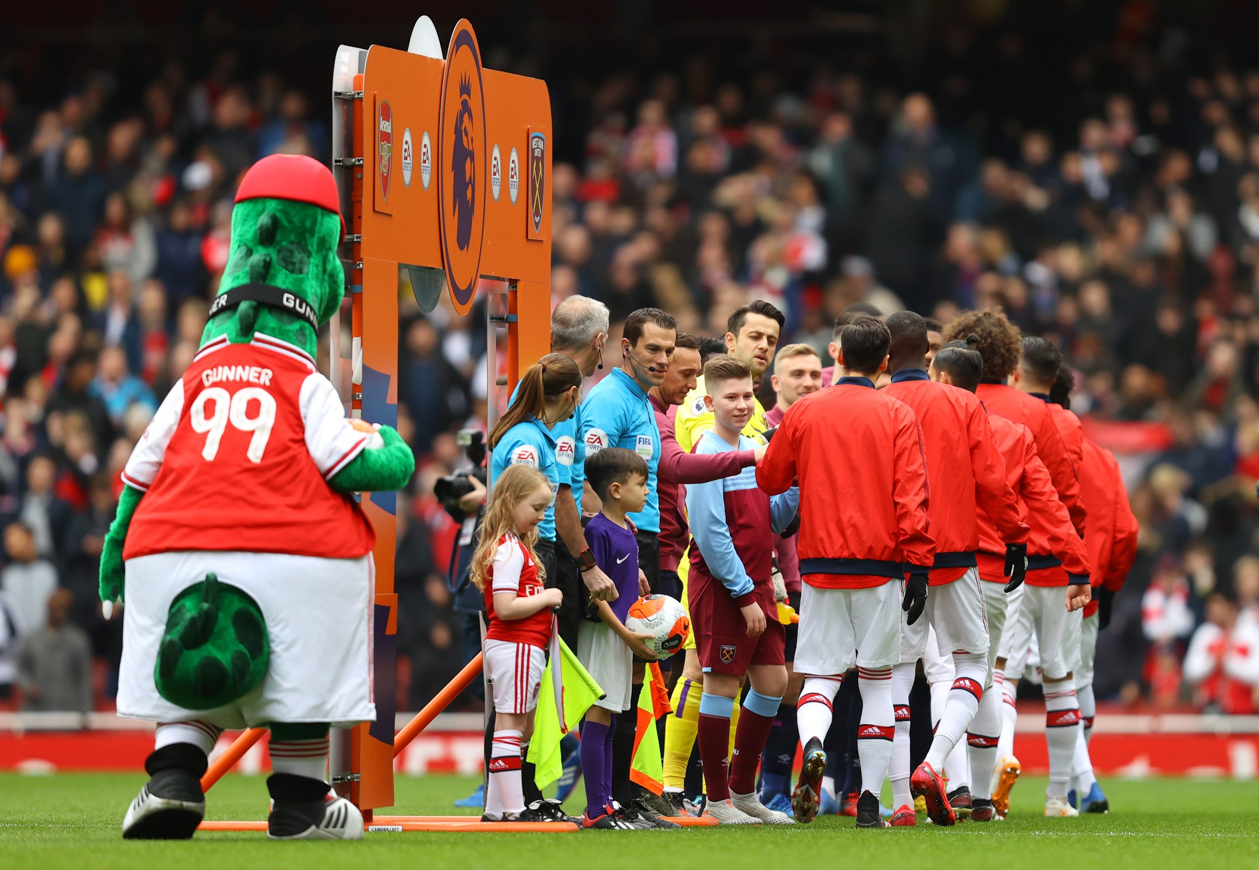 Players of Arsenal and West Ham United give each other a fist bump instead of a handshake prior to the Premier League match between Arsenal FC and ...
