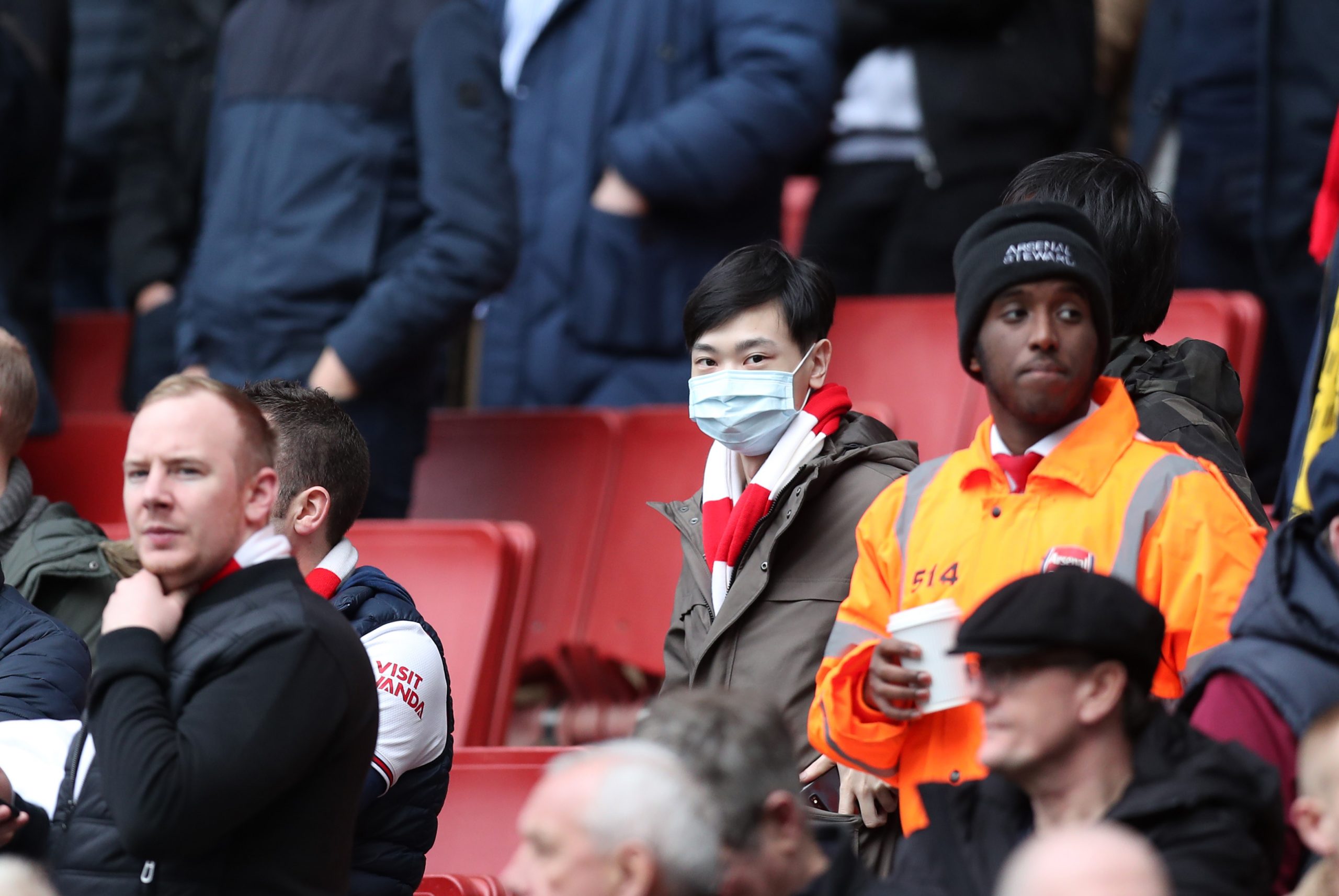A fan wears a disposable face mask during the Premier League match between Arsenal FC and West Ham United at Emirates Stadium on March 07, 2020 in ...