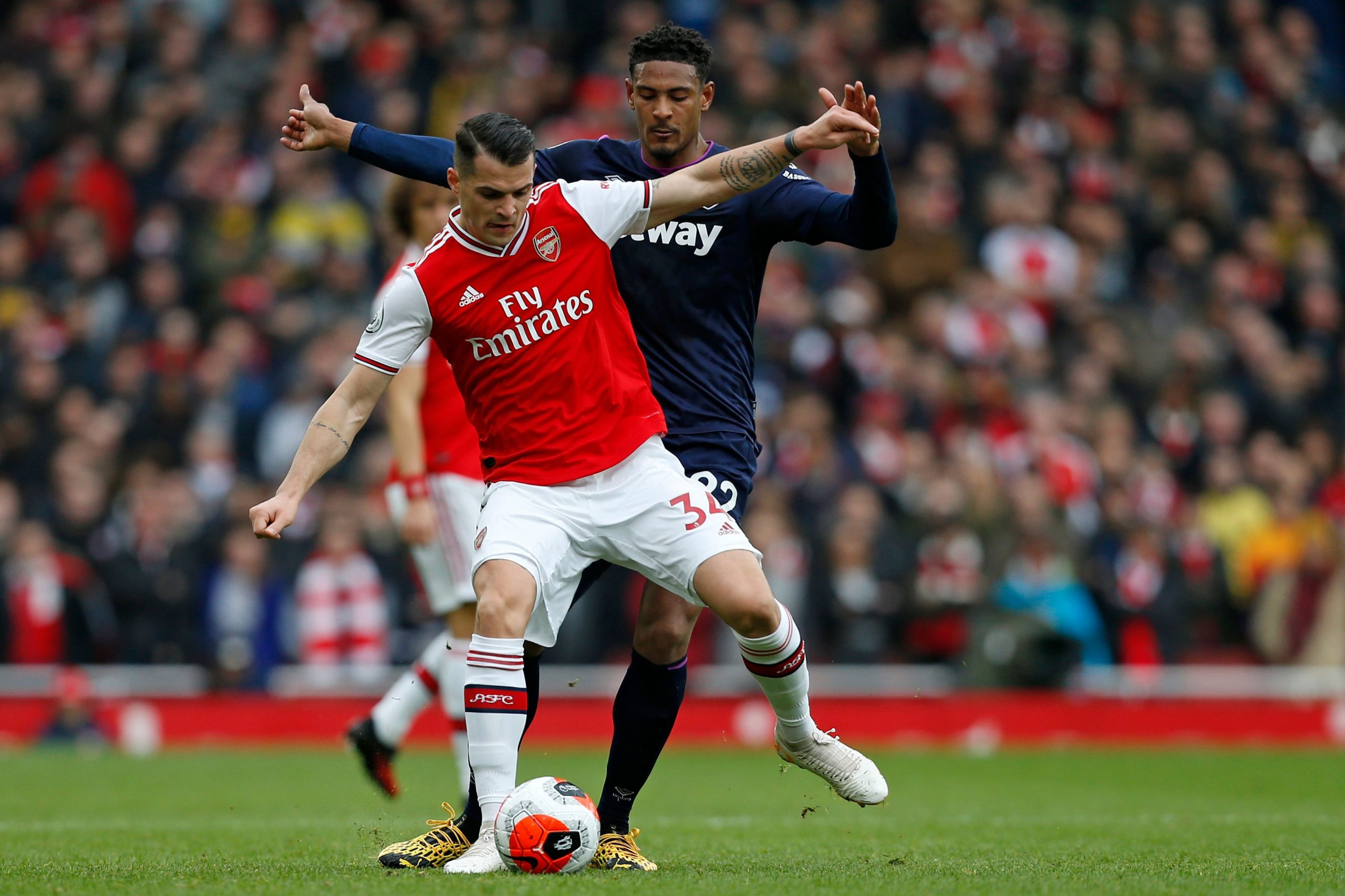 Arsenal's Swiss midfielder Granit Xhaka (L) vies with West Ham United's French striker Sebastien Haller (R) during the English Premier League footb...