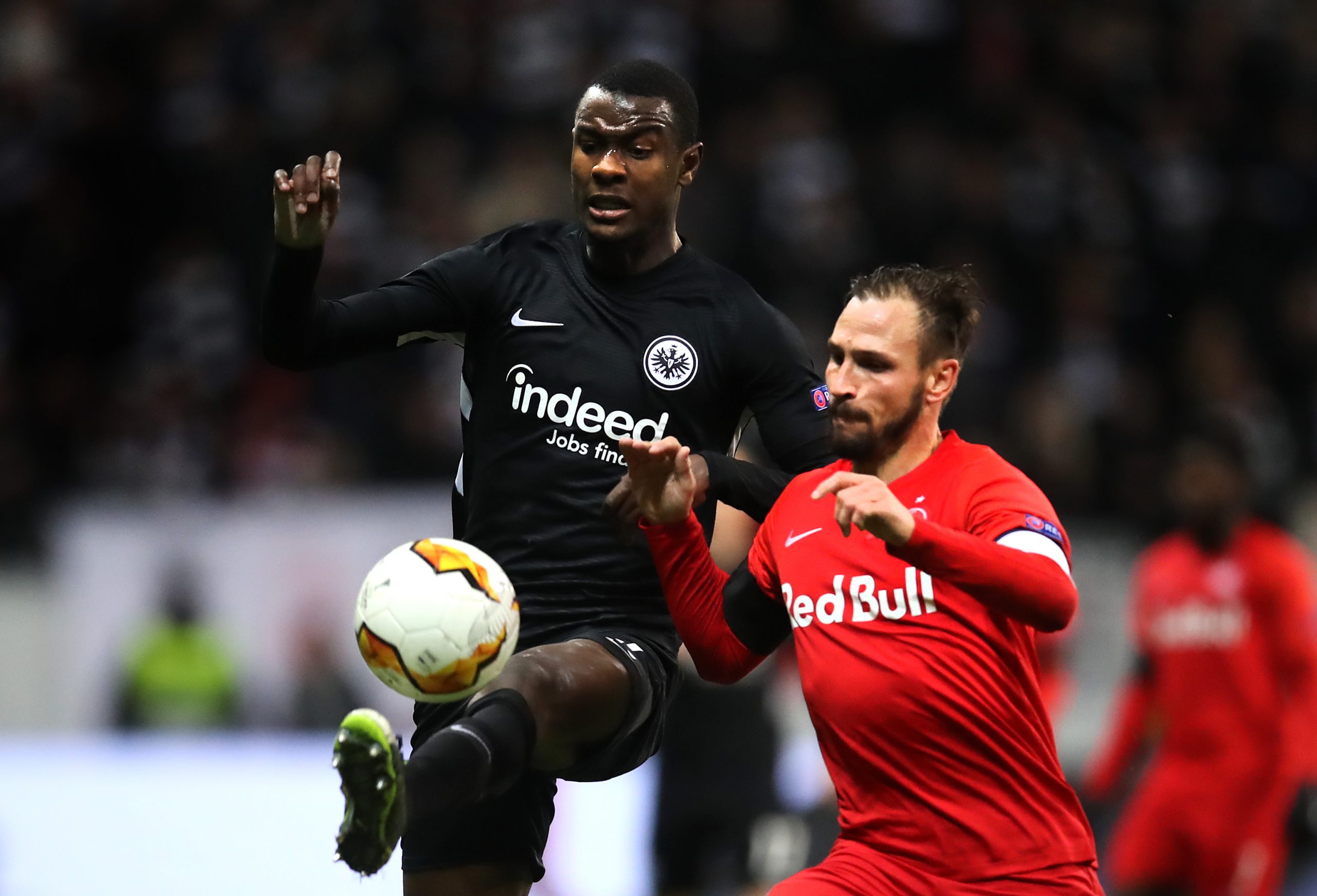 FRANKFURT AM MAIN, GERMANY - FEBRUARY 20: Evan N'Dicka of Eintracht Frankfurt controls the ball with pressure from Andreas Ulmer of RB Salzburg dur...