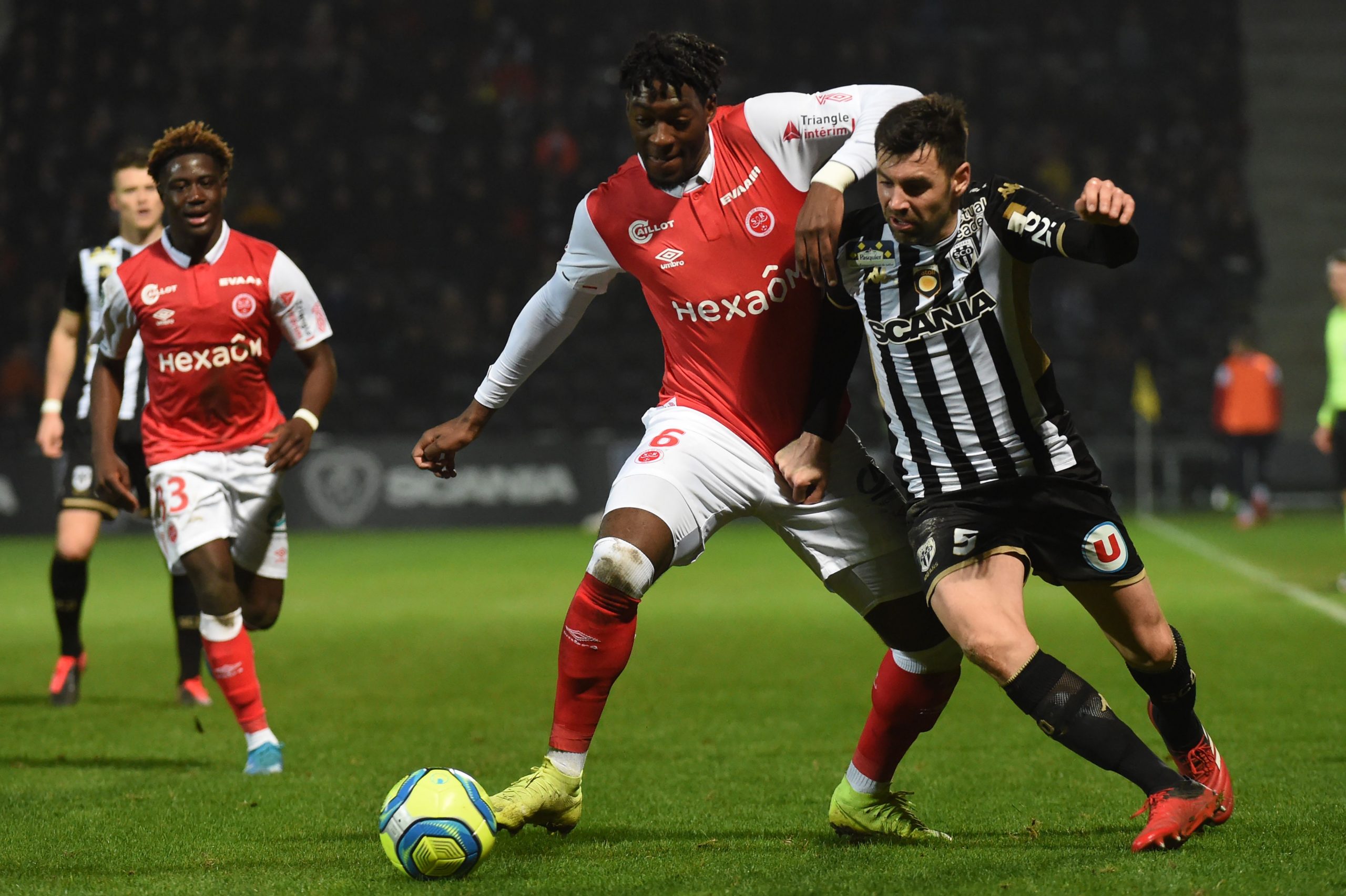 Reims' French defender Axel Disasi (C) vies with Angers' French midfielder Thomas Mangani (R) during the French L1 football match between Angers (S...
