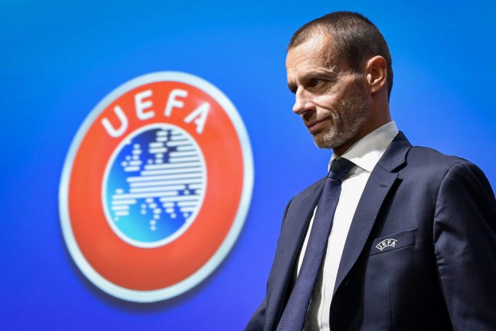 UEFA president Aleksander Ceferin walks past a sign with the UEFA logo after attending a press conference following a meeting of the executive comm...