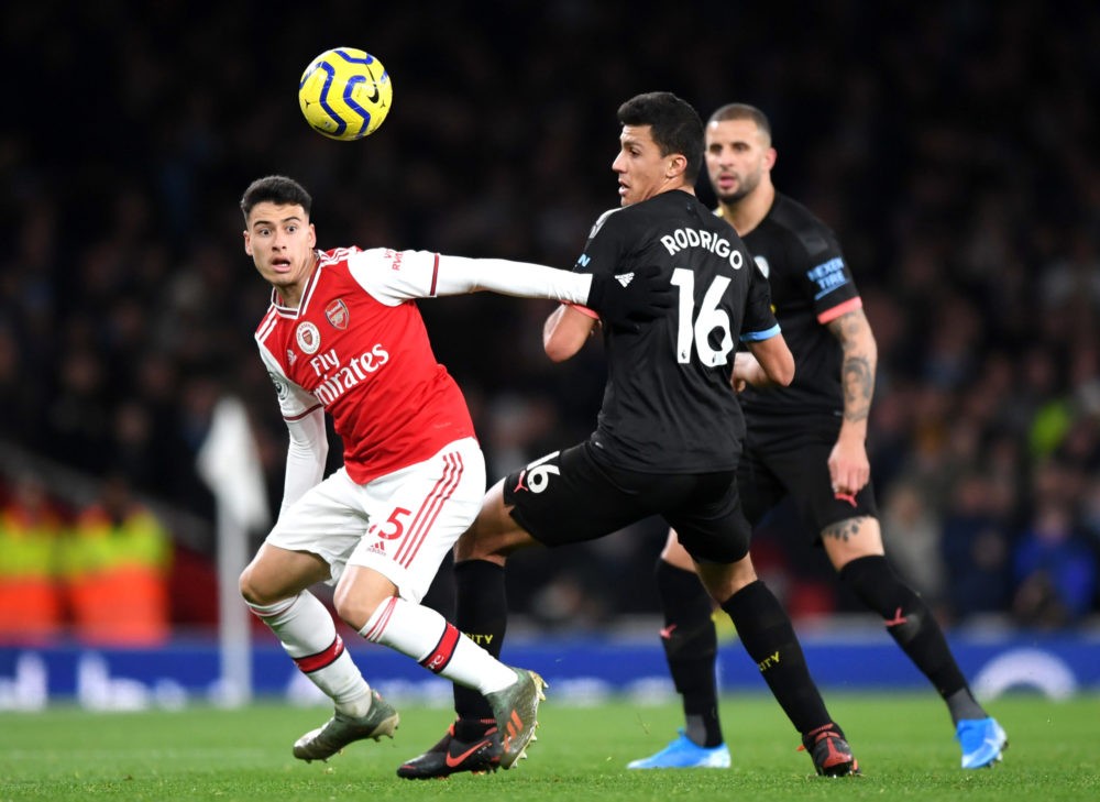 LONDON, ENGLAND - DECEMBER 15: Gabriel Martinelli of Arsenal battles for possession with Rodrigo of Manchester City during the Premier League match...