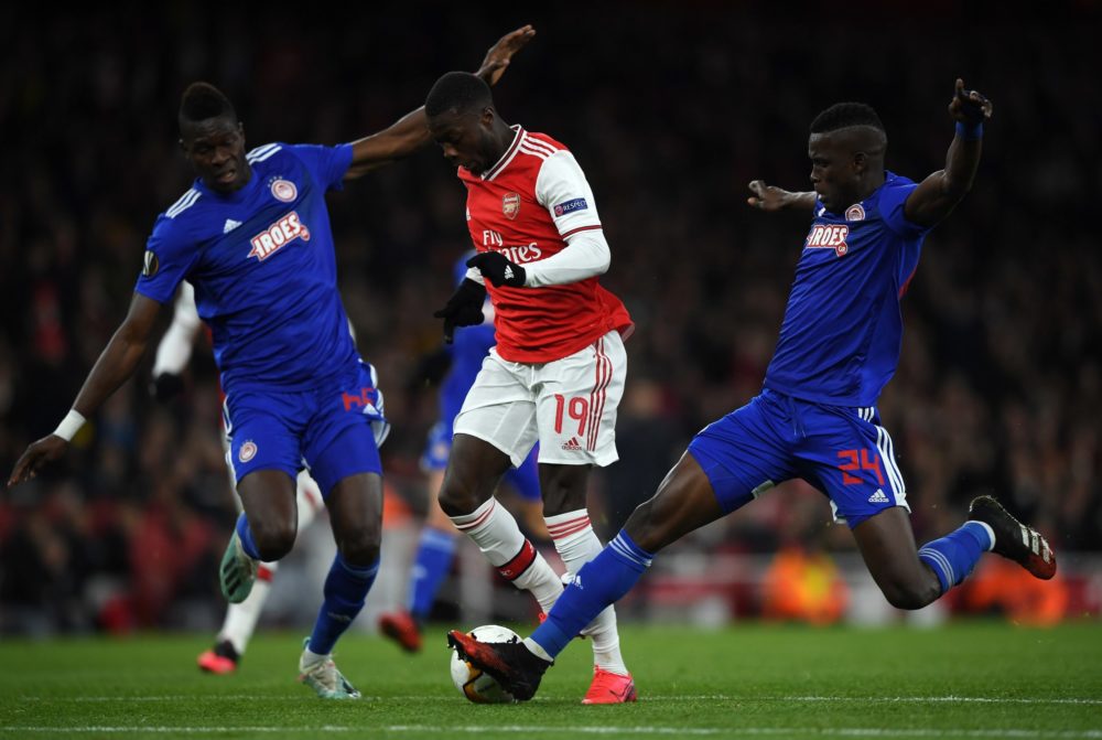 LONDON, ENGLAND - FEBRUARY 27: Nicolas Pepe of Arsenal FC is tackled by Pape Abou Cisse and Ousseynou Ba of Olympiacos FC during the UEFA Europa League round of 32 second leg match between Arsenal FC and Olympiacos FC at Emirates Stadium on February 27, 2020 in London, United Kingdom. (Photo by Mike Hewitt/Getty Images)