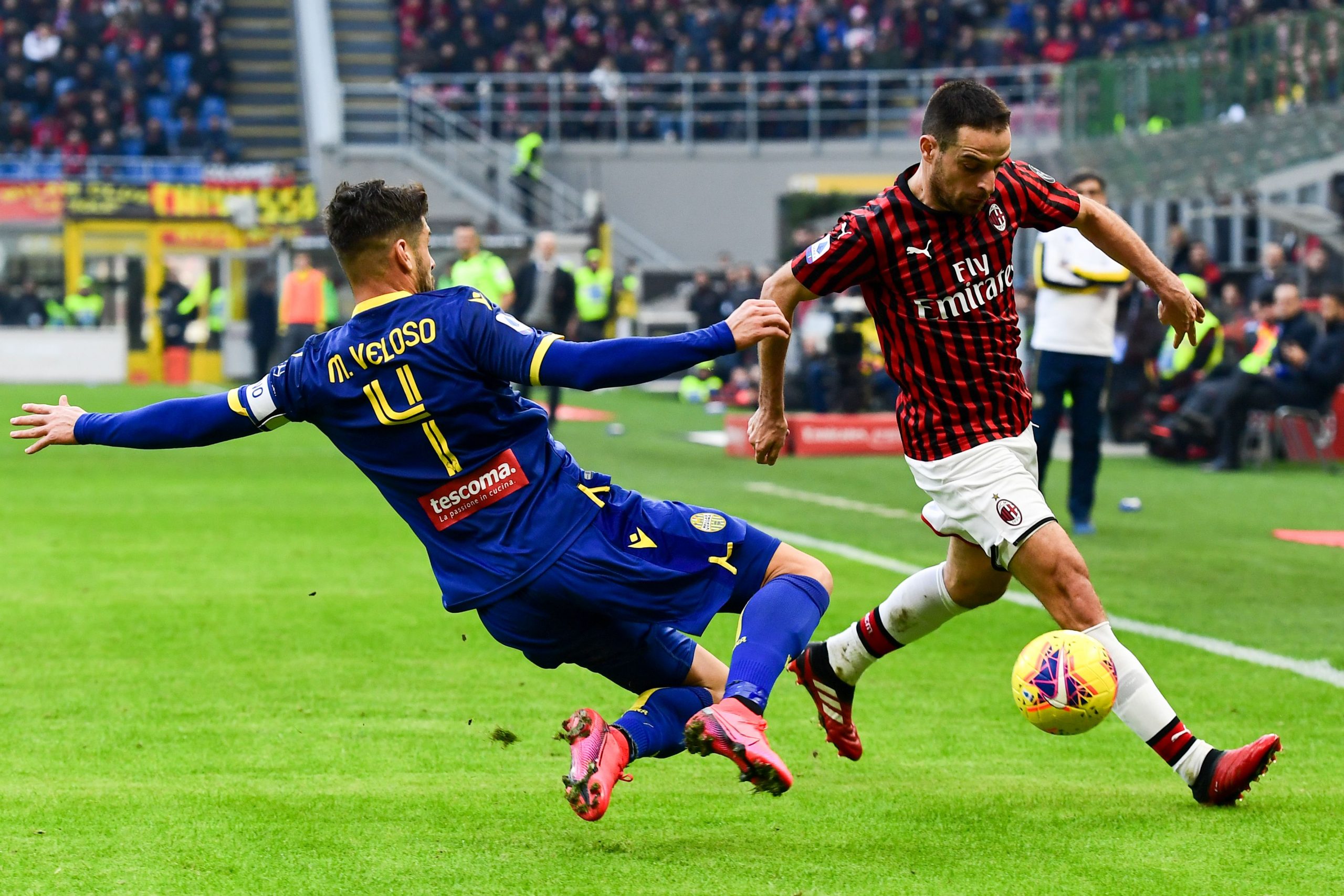 Verona's Portuguese midfielder Miguel Veloso (L) tackles AC Milan's Italian midfielder Giacomo Bonaventura during the Italian Serie A football matc...