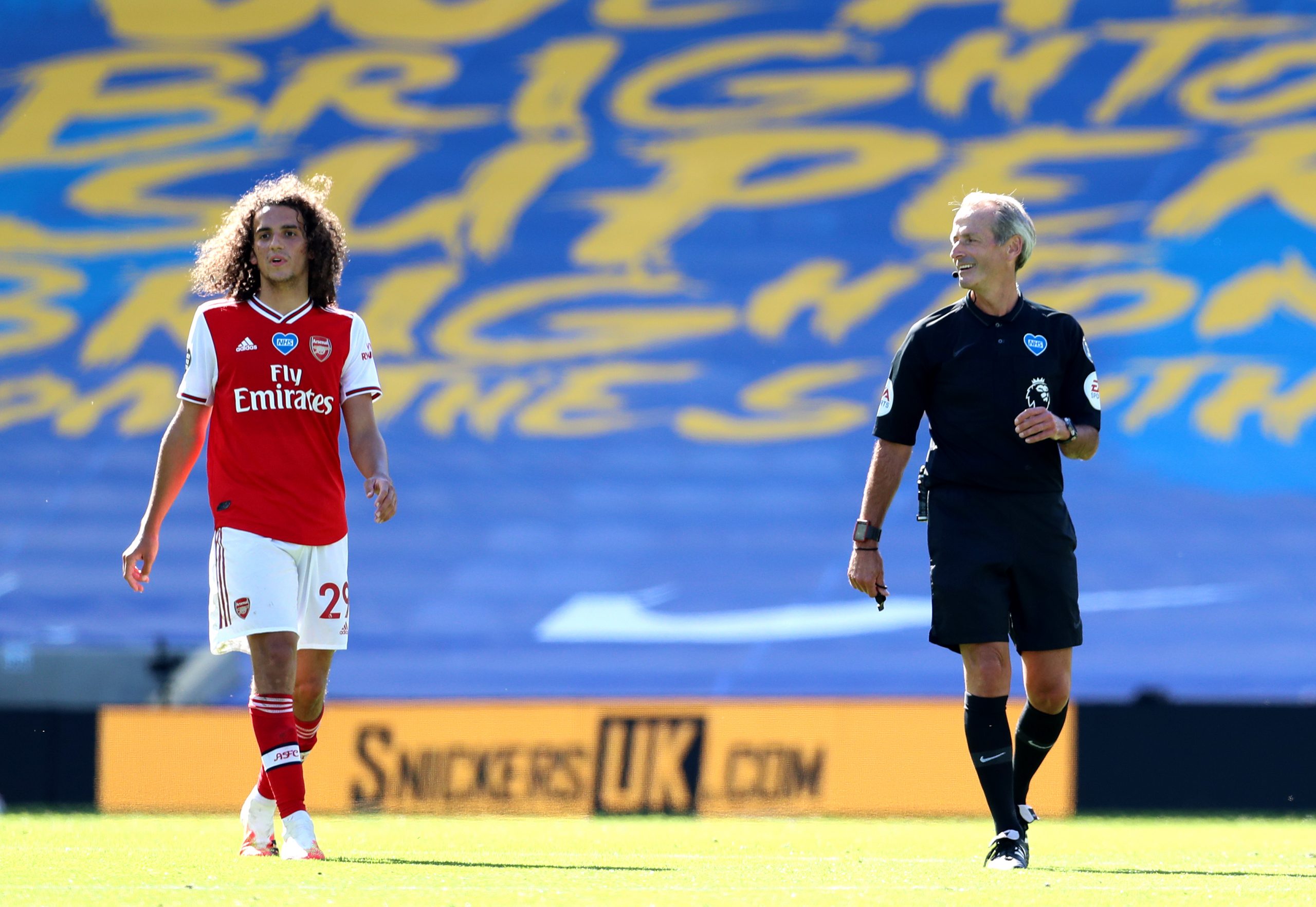 BRIGHTON, ENGLAND - JUNE 20: Referee Martin Atkinson speaks to Matteo Guendouzi of Arsenal during the Premier League match between Brighton & H...