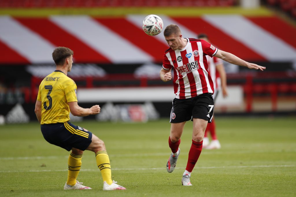 SHEFFIELD, ENGLAND - JUNE 28: John Lundstram of Sheffield United wins a header over Kieran Tierney of Arsenal during the FA Cup Fifth Quarter Final match between Sheffield United and Arsenal FC at Bramall Lane on June 28, 2020 in Sheffield, England. (Photo by Andrew Boyers/Pool via Getty Images)