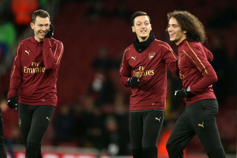 Arsenal's Swiss defender Stephan Lichtsteiner (L), Arsenal's German midfielder Mesut Ozil (C) and Arsenal's French midfielder Matteo Guendouzi (R) warm up ahead of the English FA Cup fourth round football match between Arsenal and Manchester United at the Emirates Stadium in London on January 25, 2019. (Photo by Daniel LEAL-OLIVAS / AFP)