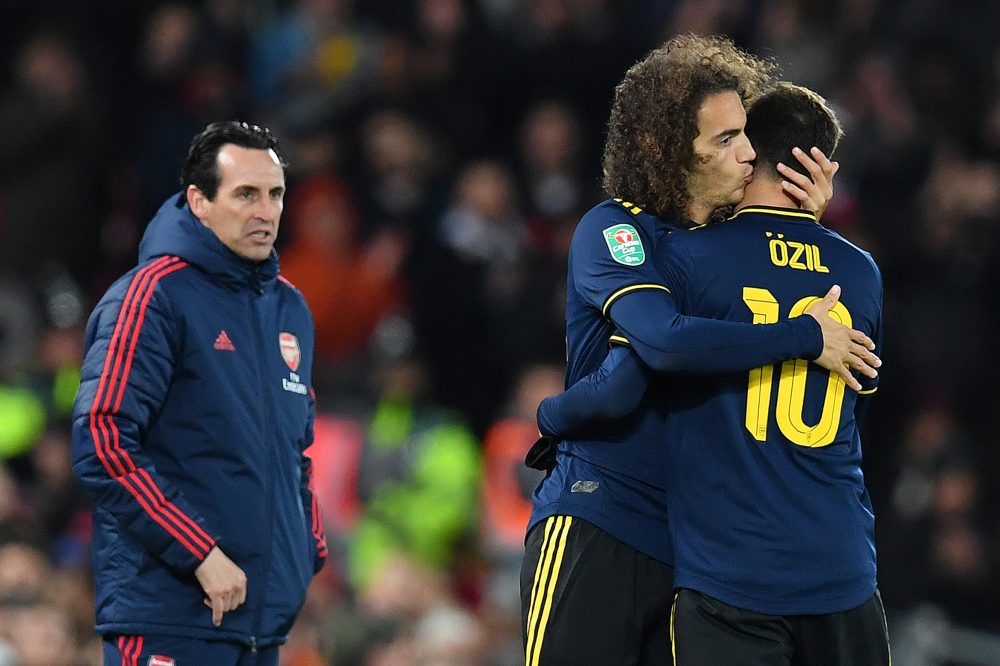 Arsenal's Spanish head coach Unai Emery (L) watches as Arsenal's German midfielder Mesut Ozil leaves the pitch after being substituted off for Arsenal's French midfielder Matteo Guendouzi during the English League Cup fourth round football match between Liverpool and Arsenal at Anfield in Liverpool, north west England on October 30, 2019. (Photo by Paul ELLIS / AFP)  (Photo by PAUL ELLIS/AFP via Getty Images)