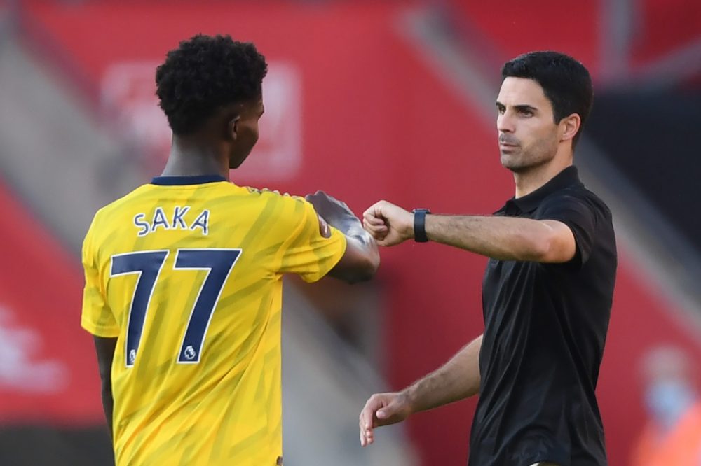 Arsenal's Spanish head coach Mikel Arteta (R) gestures with Arsenal's English striker Bukayo Saka at the final whistle during the English Premier L...