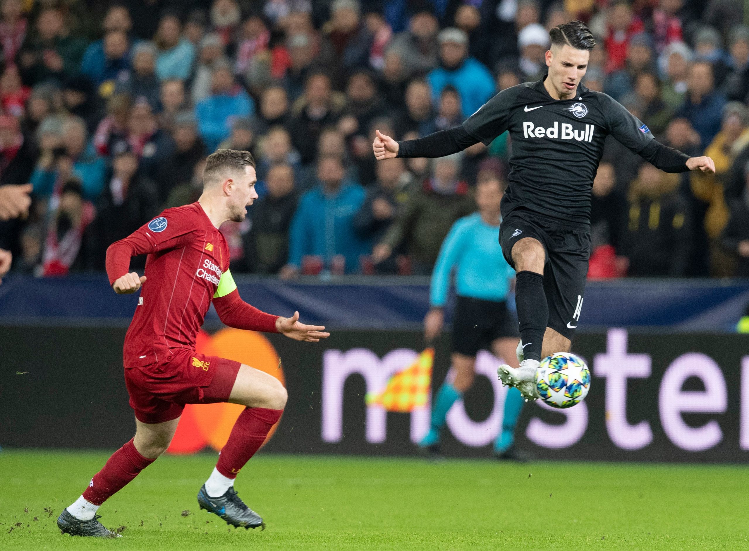 Salzburg's Hungarian midfielder Dominik Szoboszlai kicks the ball watched by Liverpool's English midfielder Jordan Henderson vie for the ball durin...