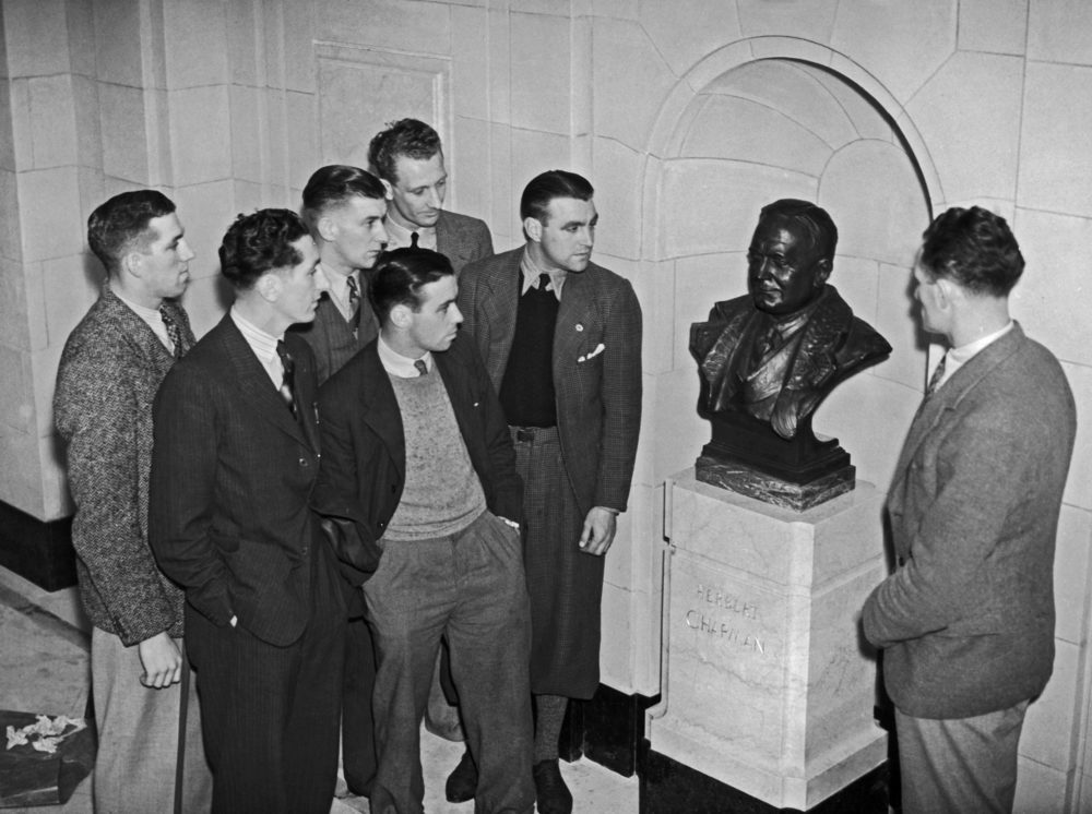 A group of Arsenal players admire a bronze memorial bust of the late club manager Herbert Chapman by Jacob Epstein, on display at the Arsenal Stadium in London, October 1936. Amongst them are Herbert Roberts, Eddie Hapgood, Bobby Davidson, Jack Crayston and Frank Moss. (Photo by Topical Press Agency/Hulton Archive/Getty Images)