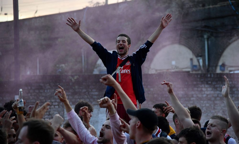 Arsenal fans celebrate outside the Emirates stadium in north London on August 1, 2020, after their team won the English FA Cup final football match against Chelsea. - Arsenal won the match 2-1. (Photo by JUSTIN TALLIS / AFP)