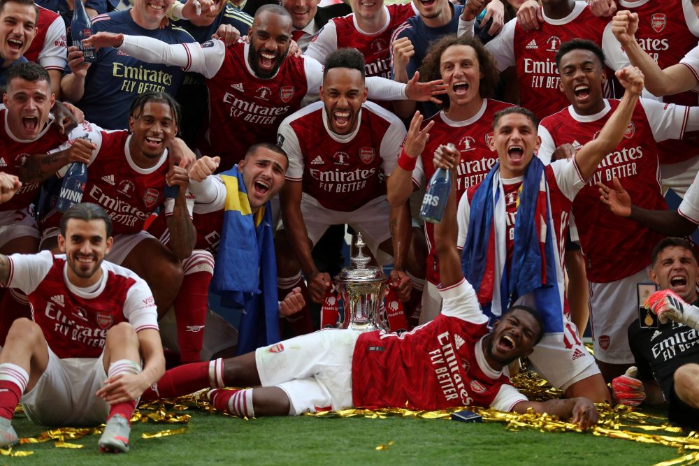 Arsenal's Gabonese striker Pierre-Emerick Aubameyang holds the winner's trophy as the team celebrates victory after the English FA Cup final footba...