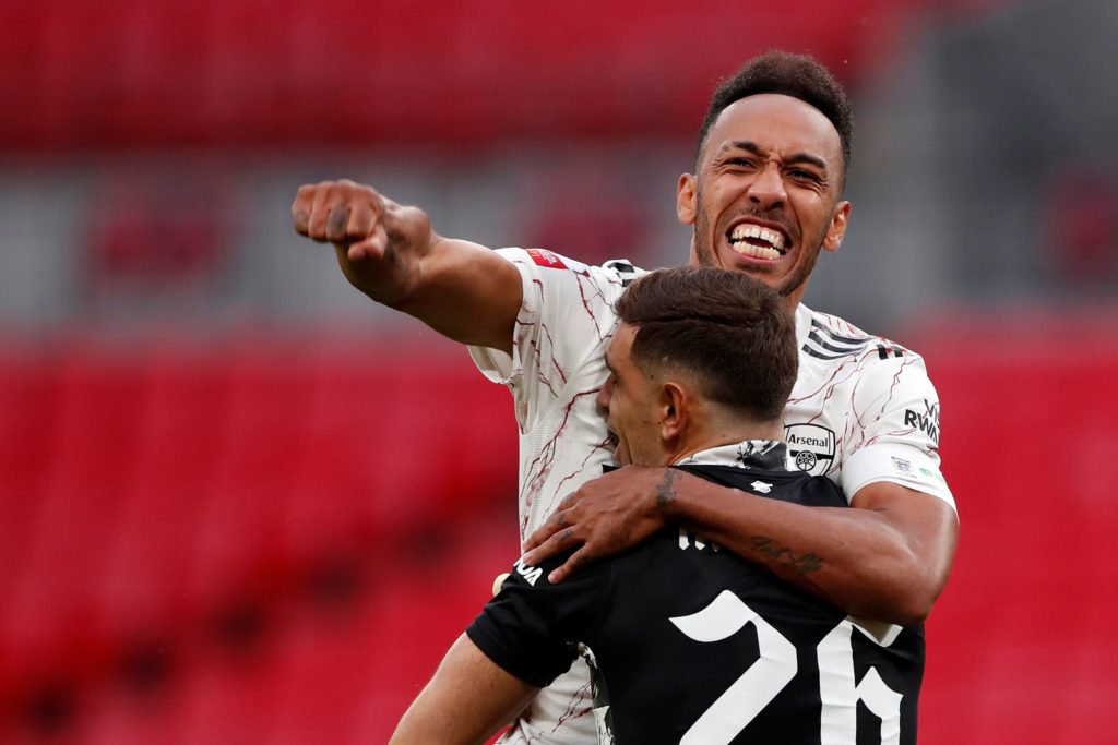 Arsenal's Gabonese striker Pierre-Emerick Aubameyang reacts to scoring the winning penalty as he jumps into the arms of Arsenal's Argentinian goalkeeper Emiliano Martinez during the shoot-out during the English FA Community Shield football match between Arsenal and Liverpool at Wembley Stadium in north London on August 29, 2020. (Photo by ANDREW COULDRIDGE/POOL/AFP via Getty Images)