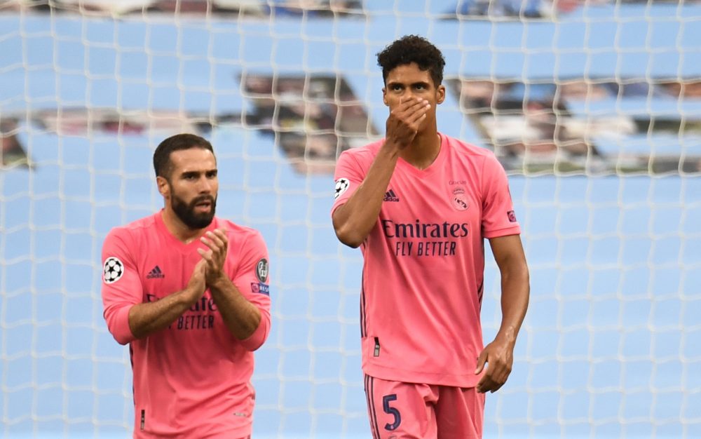 Real Madrid's French defender Raphael Varane (R) reacts after Manchester City's English midfielder Raheem Sterling (unseen) scored his team's first goal during the UEFA Champions League round of 16 second leg football match between Manchester City and Real Madrid at the Etihad Stadium in Manchester, north west England on August 7, 2020. (Photo by PETER POWELL / POOL / AFP) 