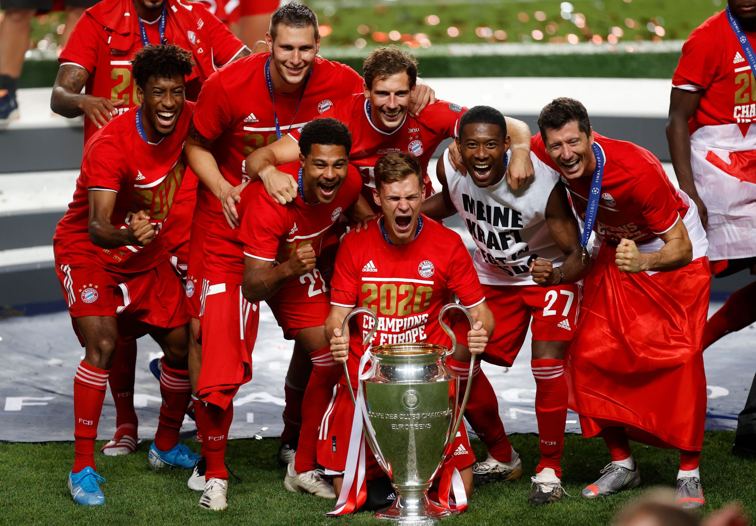Bayern Munich's German midfielder Joshua Kimmich (C holding tyrophy), Bayern Munich's French forward Kingsley Coman (L), Bayern Munich's Polish forward Robert Lewandowski (R) and teammates celebrate after Bayern won the UEFA Champions League final football match between Paris Saint-Germain and Bayern Munich at the Luz stadium in Lisbon on August 23, 2020. (Photo by MATTHEW CHILDS / POOL / AFP) 