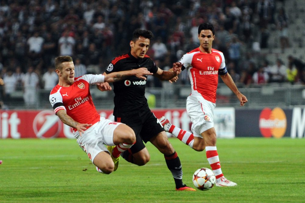 Besiktas' Mustafa Pektemek (C) vies with Arsenal's Jack Wilshere (L) and Mikel Arteta (R) during the UEFA Champions League play-off football match Besiktas vs Arsenal at Ataturk Olympic Stadium on August 19,2014 in Istanbul. AFP PHOTO / OZAN KOSE (Photo credit should read BULENT KILIC/AFP via Getty Images)