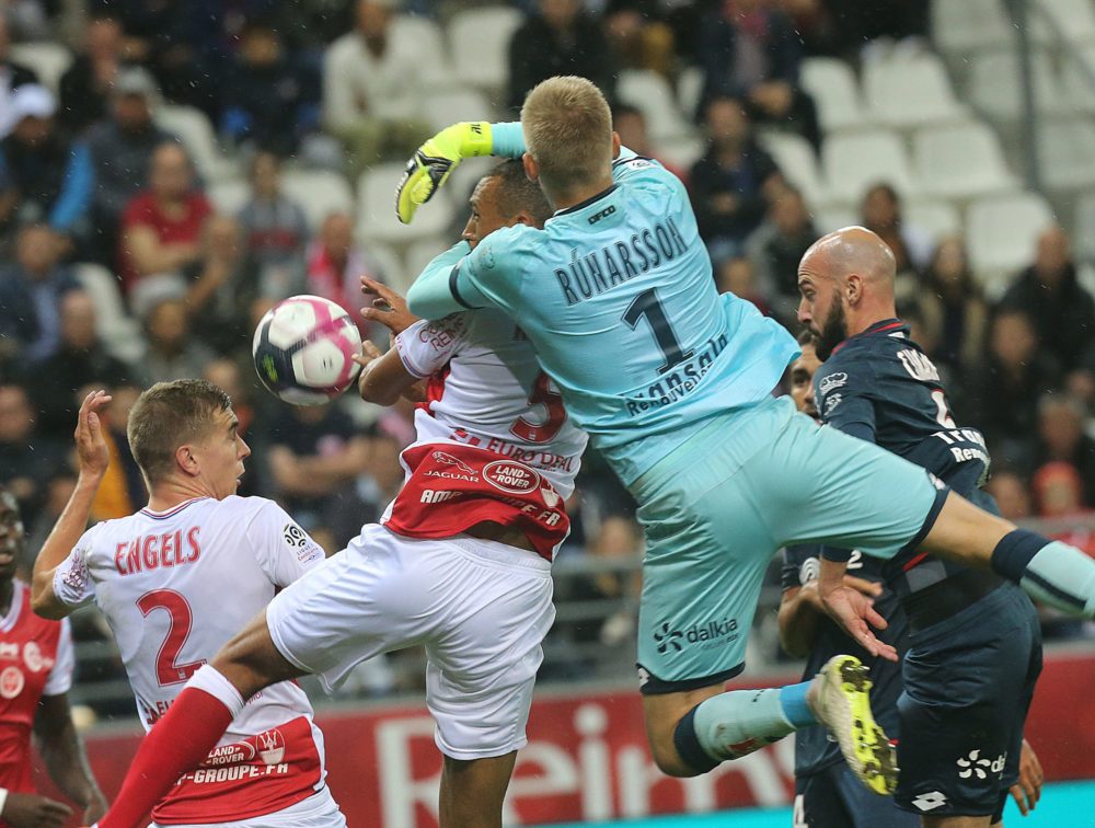 Reims' Moroccoan defender Yunis Abdedlhamid (L) vies with Dijon's Iceland goalkeeper Runar Alex Runarsson (R) during the French L1 football match between Reims and Dijon on September 22, 2018 at the Auguste Delaune Stadium in Reims. (Photo by FRANCOIS NASCIMBENI / AFP)