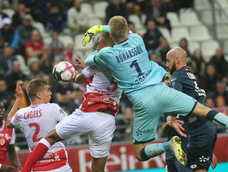 Reims' Moroccoan defender Yunis Abdedlhamid (L) vies with Dijon's Iceland goalkeeper Runar Alex Runarsson (R) during the French L1 football match b...