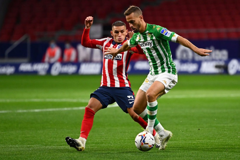 Atletico Madrid's Uruguayan midfielder Lucas Torreira (L) vies with Real Betis' Spanish midfielder Sergio Canales during the Spanish League footbal...