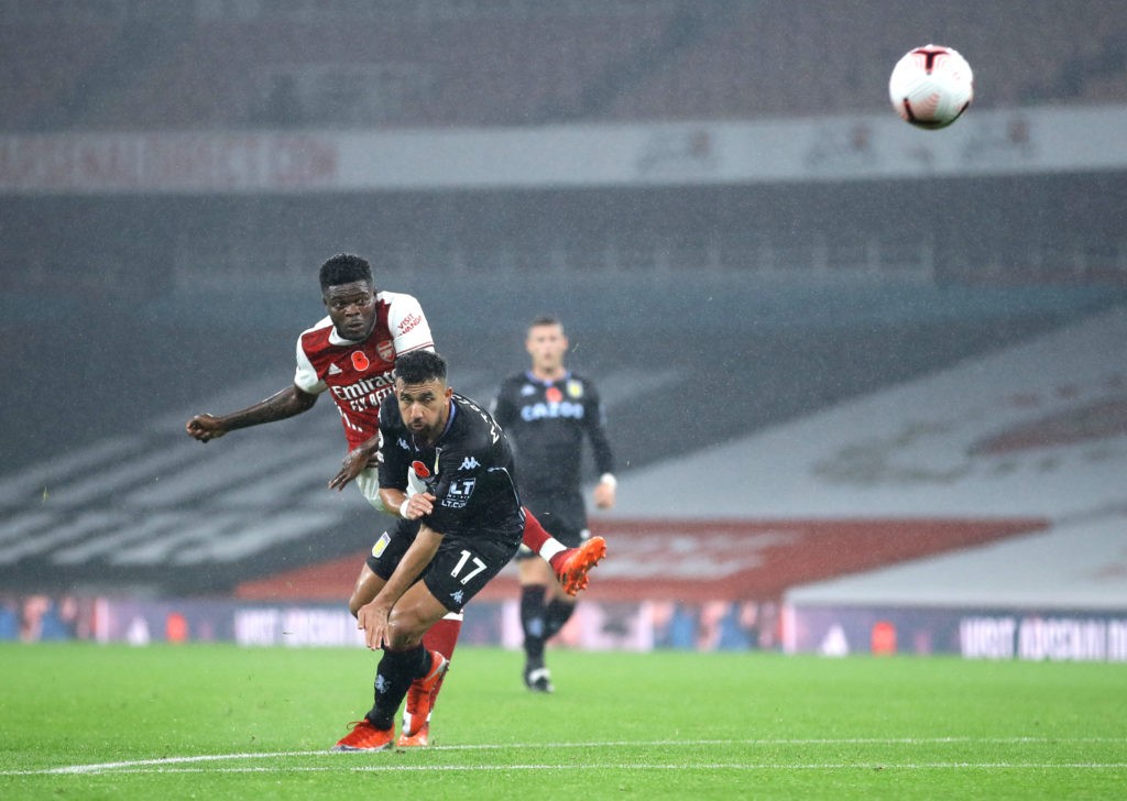LONDON, ENGLAND - NOVEMBER 08: Thomas Partey of Arsenal shoots under pressure from Trezeguet of Aston Villa during the Premier League match between Arsenal and Aston Villa at Emirates Stadium on November 08, 2020 in London, England. Sporting stadiums around the UK remain under strict restrictions due to the Coronavirus Pandemic as Government social distancing laws prohibit fans inside venues resulting in games being played behind closed doors. (Photo by Richard Heathcote/Getty Images)
