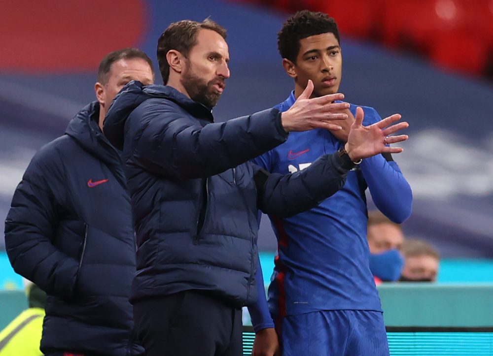 England's manager Gareth Southgate (L) gives advice to England's midfielder Jude Bellingham (R) before bringing him on to make his debut during the...