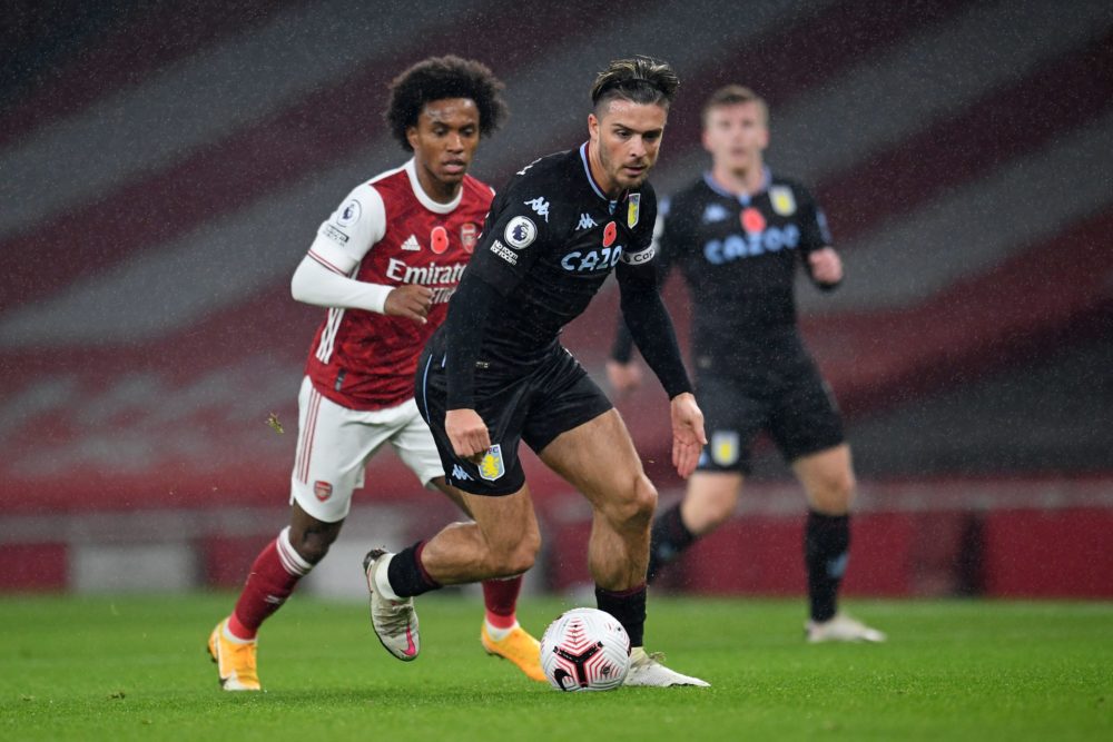 Aston Villa's English midfielder Jack Grealish (C) runs with the ball as Arsenal's Brazilian midfielder Willian (L) chases him during the English P...