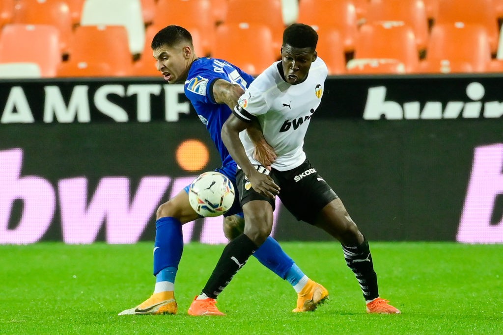 Getafe's Uruguayan defender Mathias Olivera (L) challenges Valencia midfielder Yunus Musah during the Spanish League football match between Valencia and Getafe at the Mestalla stadium in Valencia on November 1, 2020. (Photo by JOSE JORDAN/AFP via Getty Images)