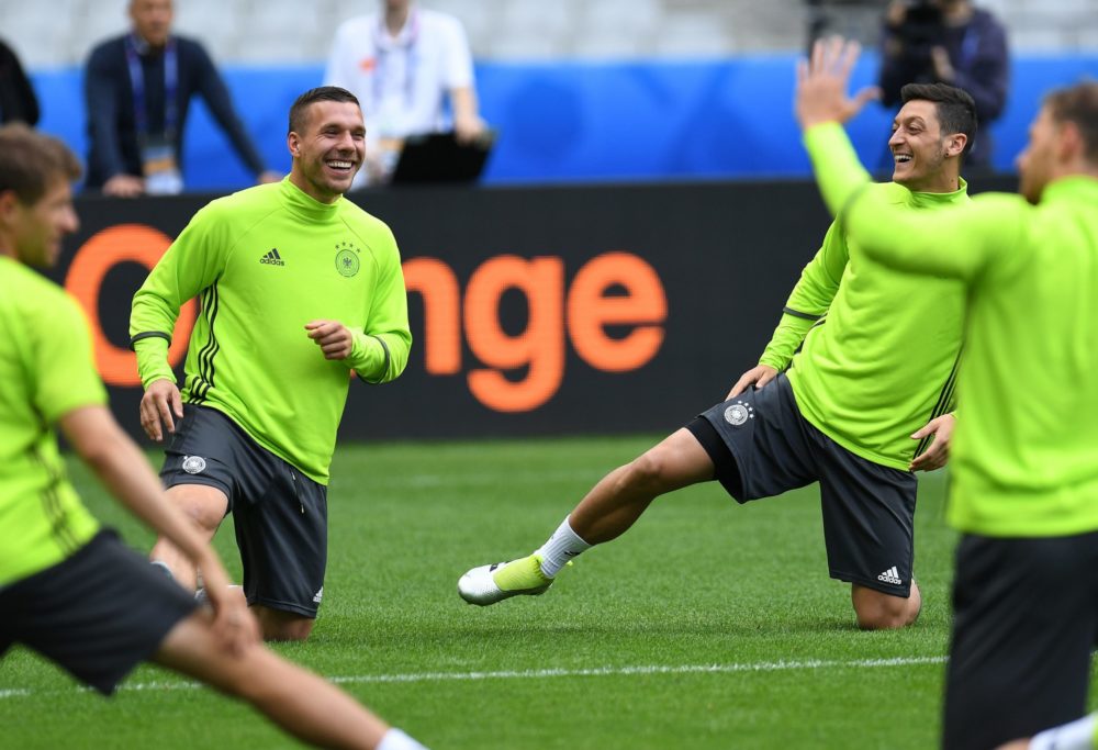 Germany's midfielder Lukas Podolski (L) and Germany's midfielder Mesut Oezil warm up during a training session at the stadium Stade de France in St.Denis , France on June 15, 2016 on the eve of the Euro 2016 football match between Germany and Poland. / AFP / PATRIK STOLLARZ