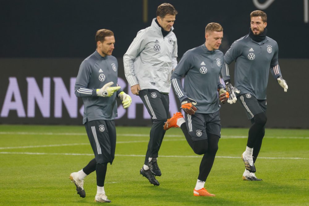 Germany's goalkeeper Kevin Trapp (R) warms up next to team manager Oliver Bierhoff and Germany's goalkeeper Bernd Leno (2nd R) during a training se...