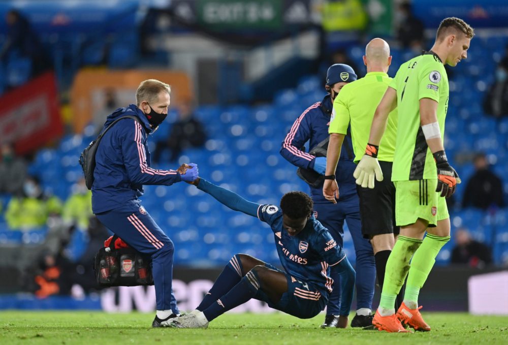 Bukayo Saka injury - LEEDS, ENGLAND - NOVEMBER 22: Bukayo Saka of Arsenal receives medical treatment during the Premier League match between Leeds United and Arsenal at Elland Road on November 22, 2020 in Leeds, England. Sporting stadiums around the UK remain under strict restrictions due to the Coronavirus Pandemic as Government social distancing laws prohibit fans inside venues resulting in games being played behind closed doors. (Photo by Paul Ellis - Pool/Getty Images)