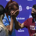 Argentine transgender footballer Mara Gomez (C) of Villa San Carlos reacts as she is given a jersey of Lanus with her name on it as present after an Argentina first division female football match against Between Villa San Carlos and Lanus at Genacio Salice stadium in Berisso, Buenos Aires, Argentina on December 7, 2020. - Gomez is the first transgender footballer to play in the first division of the Argentine female league. (Photo by JUAN MABROMATA / AFP)