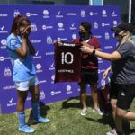 Argentine transgender footballer Mara Gomez (L) of Villa San Carlos reacts as she is given a jersey of Lanus with her name on it as present after an Argentina first division female football match against Between Villa San Carlos and Lanus at Genacio Salice stadium in Berisso, Buenos Aires, Argentina on December 7, 2020. - Gomez is the first transgender footballer to play in the first division of the Argentine female league. (Photo by JUAN MABROMATA / AFP)