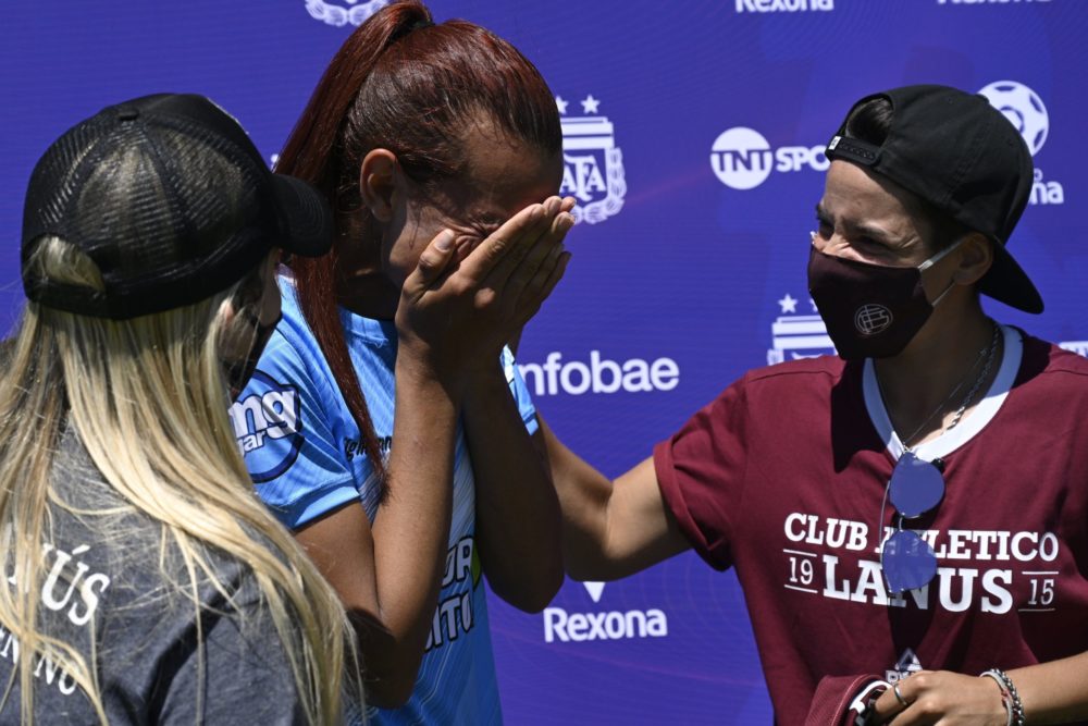 Argentine transgender footballer Mara Gomez (C) of Villa San Carlos reacts as she is given a jersey of Lanus with her name on it as present after a...