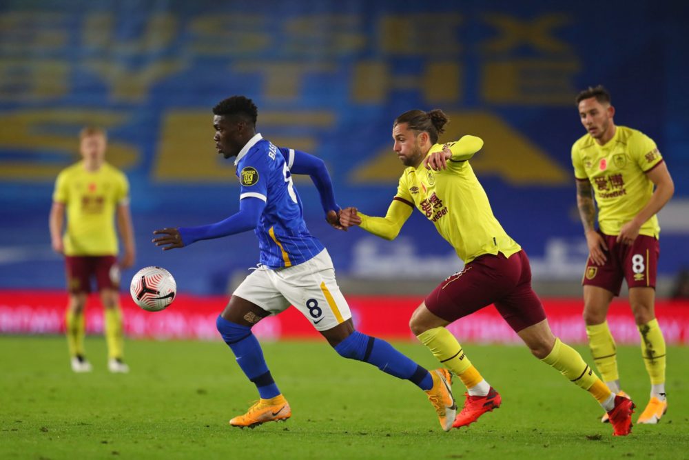 Brighton's Ivorian midfielder Yves Bissouma (C) runs with the ball as Burnley's English striker Jay Rodriguez (2nd R) chases after him during the E...